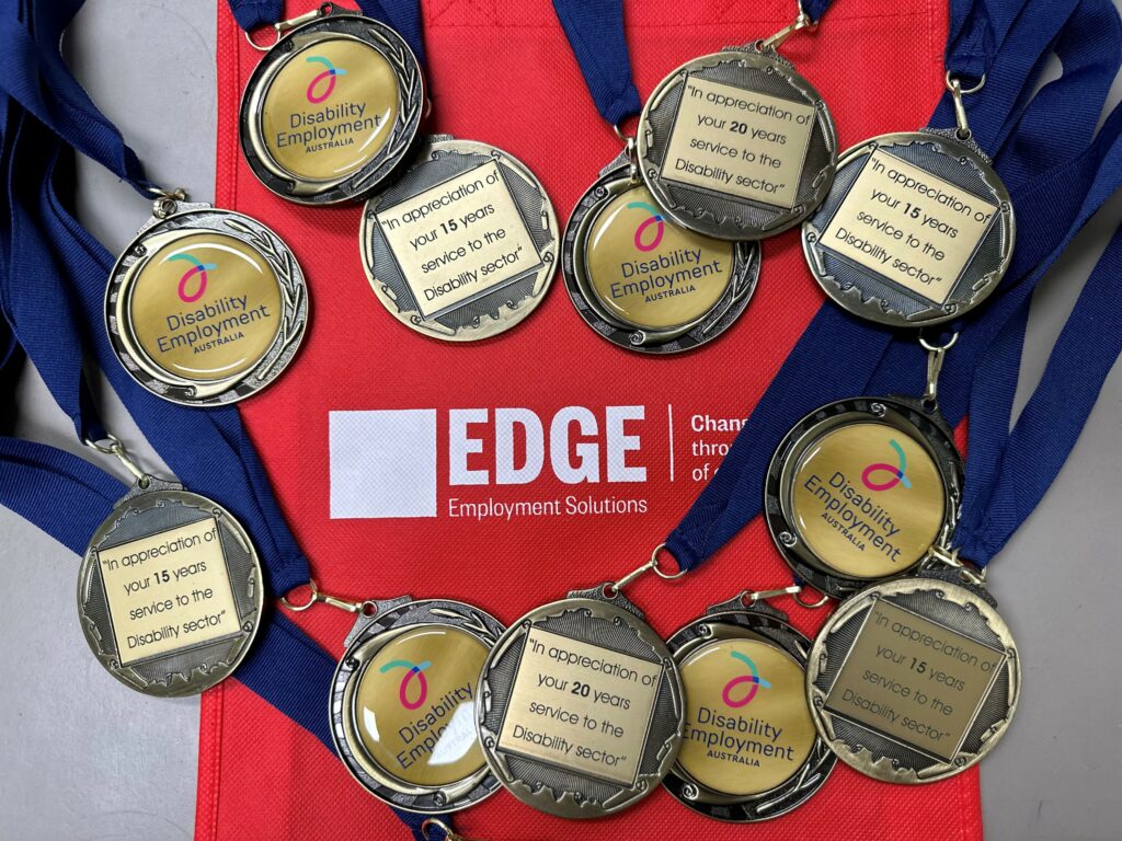 12 medals on top of a Edge branded red bag.