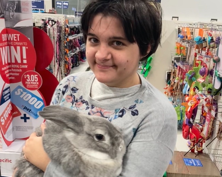 Ciara smiling while holding a rabbit.