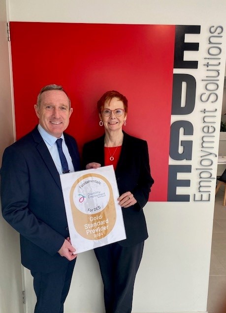 A man and woman standing side-by-side each holding a certificate that features the DEA logo and a gold graphic.