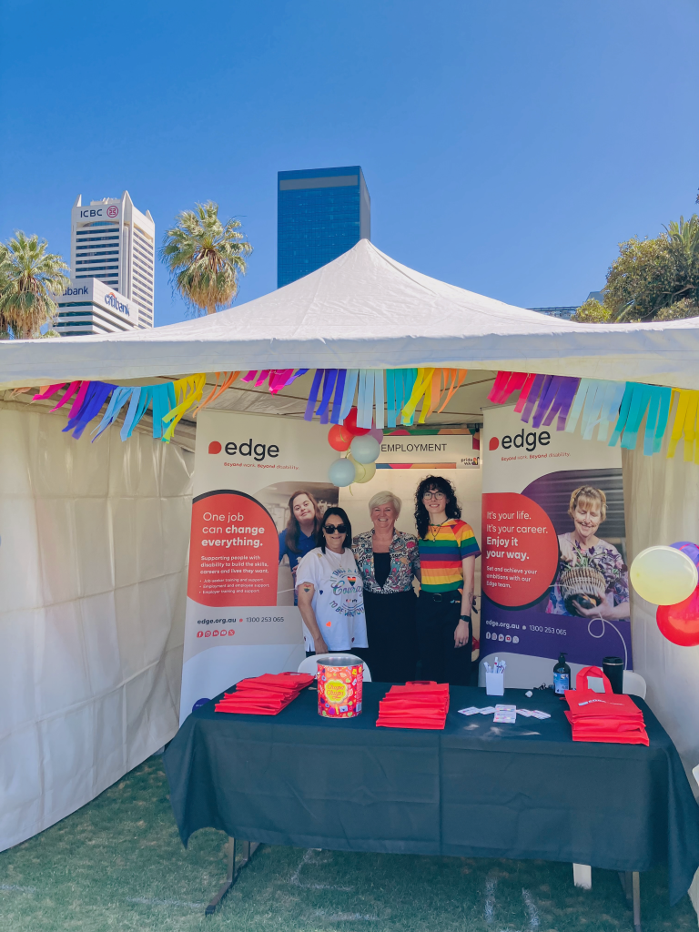 a group of people standing at a table in a vendor tent.